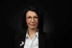 Жена с черно сако и очила, с очертани вежди и естествен грим